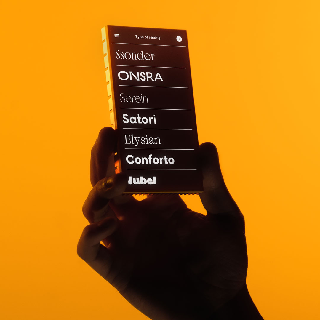 Hand holding a smartphone with the Type of Feeling website